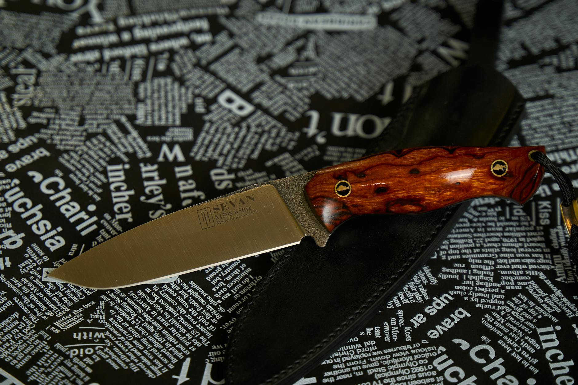 A detailed shot of a handmade knife with a polished wooden handle, set against a textured background.