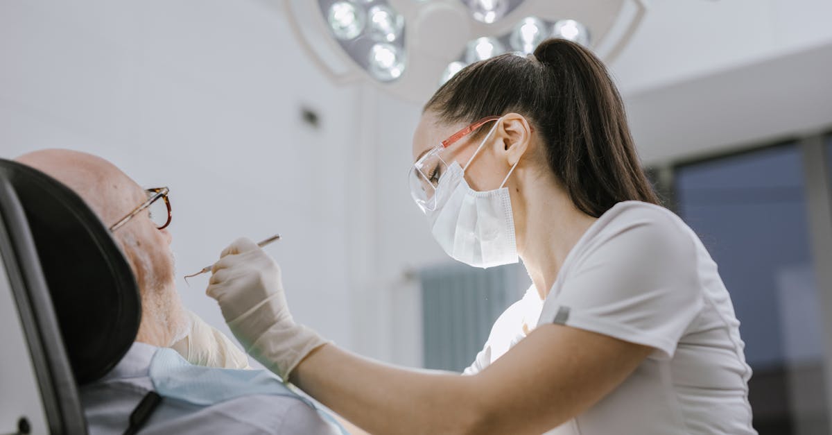 Female dentist working on a patient in a modern dental office with bright lighting.